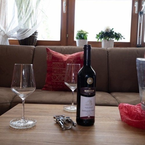 Eine Flasche Wein und zwei Weingläser stehen auf dem Couchtisch - Eine Flasche Wein und zwei Weingläser stehen auf dem Couchtisch -