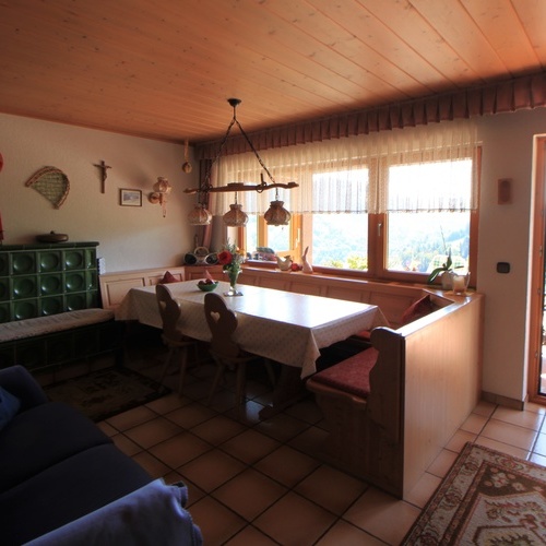 Wohnzimmer mit gro&szlig;em Esstisch, Couch, TV  und beheizbarer Ofenbank  - 