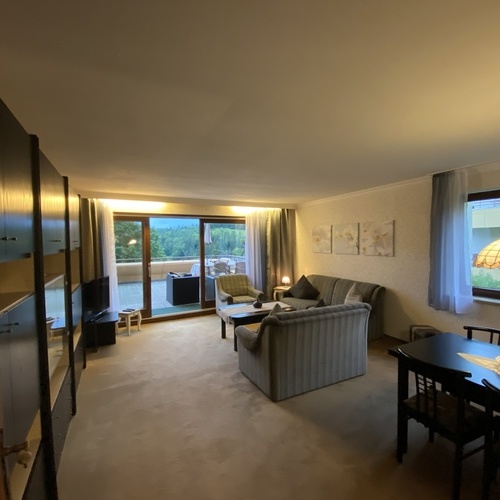 Wohnzimmer mit Sitzecke, Schrankwand und Esstisch  - 