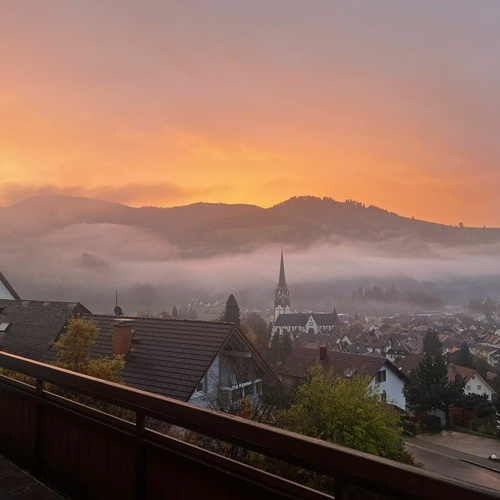 Blick von der Terrasse auf den orangef&auml;rbten Abendhimmel &uuml;ber Sch&ouml;nau - 